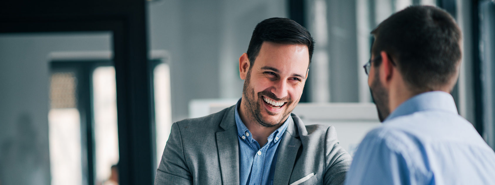 Portrait of cheerful young manager handshake with new employee.